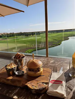a table with a sandwich on a wooden cutting board at prestigia urbane appartement marrakech in Marrakech