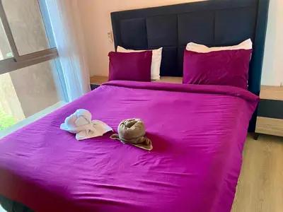 two stuffed animals sitting on a bed with pink sheets at prestigia urbane appartement marrakech in Marrakech