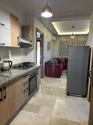 a kitchen with a refrigerator and a living room at Apartments city center in Marrakech