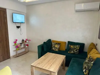 a living room with a green couch and a table at Apartments city center in Marrakech