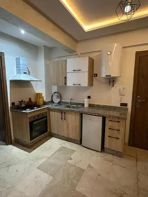 a kitchen with wooden cabinets and a counter top at Apartments city center in Marrakech