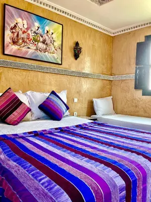 a bedroom with a large bed with colorful sheets at Riad alwafa B&B in Marrakech