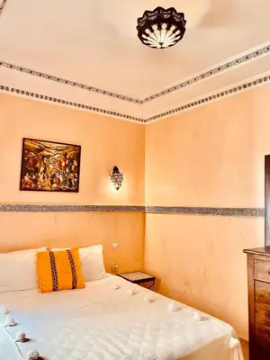 a bedroom with a bed and a painting on the wall at Riad alwafa B&B in Marrakech