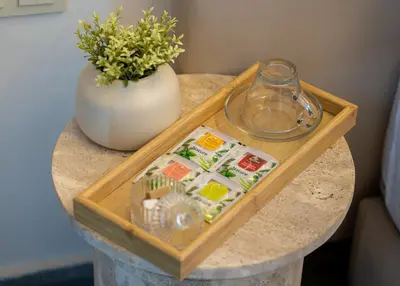 a wooden tray on a table with a vase at Spacieux 2BR à Guéliz, Centre-Ville, Moderne et Confortable in Marrakech