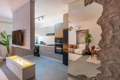 a kitchen and living room with a stone wall at Spacieux 2BR à Guéliz, Centre-Ville, Moderne et Confortable in Marrakech