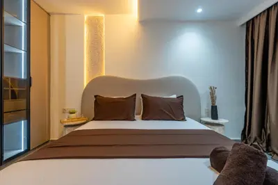 a bedroom with a large white bed with brown pillows at Spacieux 2BR à Guéliz, Centre-Ville, Moderne et Confortable in Marrakech