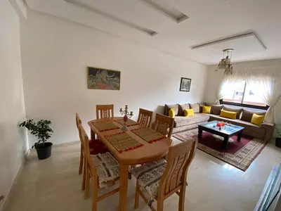 a living room with a table and a couch at Marrakech Apartment with Pool in Marrakech