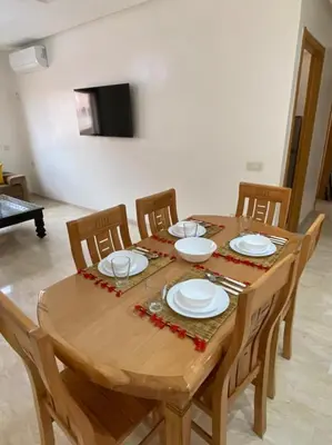 a wooden table with chairs and plates on it at Marrakech Apartment with Pool in Marrakech