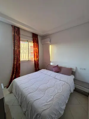 a bedroom with a large white bed in front of a window at Modern and quit appartment in Marrakech