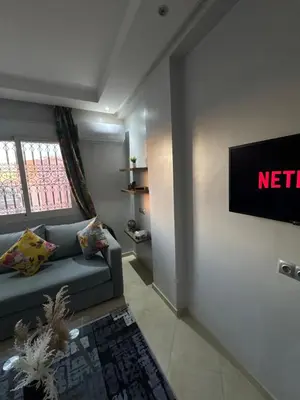 a living room with a couch and a television at Modern and quit appartment in Marrakech