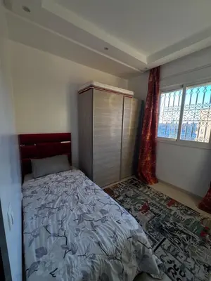 a bedroom with a bed and a dresser and windows at Modern and quit appartment in Marrakech