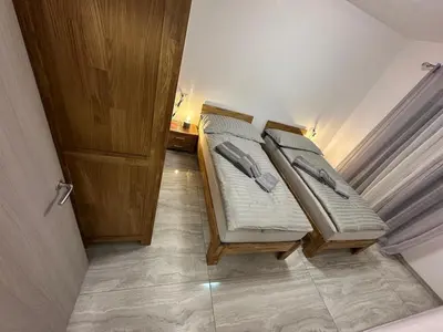 two twin beds in a small room with a door at Appartement Vacances FTS Little in Marrakech