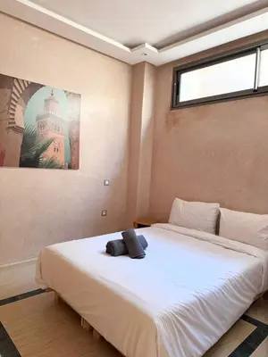 a bedroom with a large white bed with a window at Villa Akenza Marrakech in Marrakech