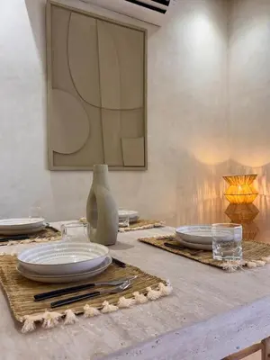a table with plates and glasses on top of it at Dar Kamyssa Le désert au cœur de Guéliz in Marrakech
