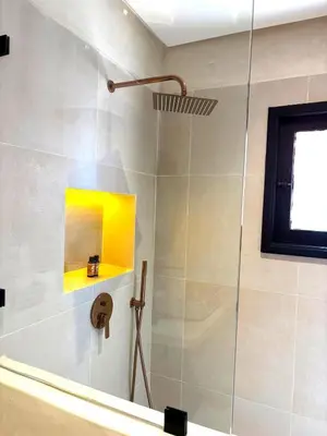 a bathroom with a shower with a glass door at Dar Kamyssa Le désert au cœur de Guéliz in Marrakech