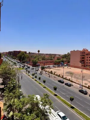 a view of a city street with cars on the road at Dar Kamyssa Le désert au cœur de Guéliz in Marrakech