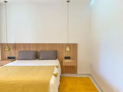 a bedroom with a large bed and a yellow rug at Villa AYA - Moderne & Chic in Sraghna