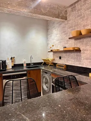 a kitchen with a washing machine and two chairs at Cozy Urban Haut Standing au cœur de Guéliz in Marrakech