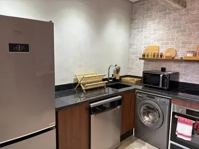 a kitchen with a washing machine and a microwave at Cozy Urban Haut Standing au cœur de Guéliz in Marrakech