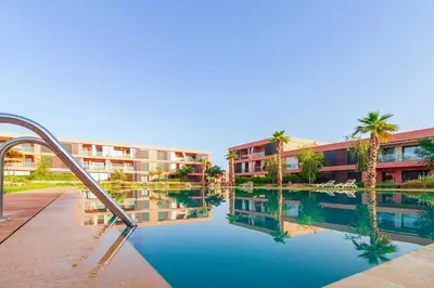 a building with a pool of water in front of a building at Beautiful Apartment with Pool View Noria Golf in Marrakech