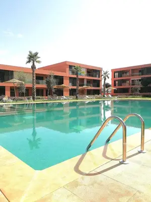 a swimming pool with a slide in front of a building at Beautiful Apartment with Pool View Noria Golf in Marrakech