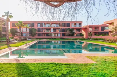 a swimming pool in front of a building at Beautiful Apartment with Pool View Noria Golf in Marrakech