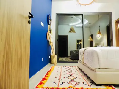 a bedroom with a bed and a chair and a mirror at Modern villa with a private pool in Marrakech