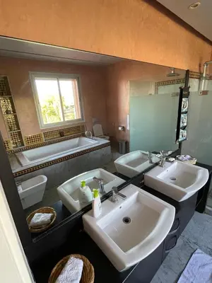 a bathroom with three sinks and a large mirror at La Villa Ocre in Marrakech