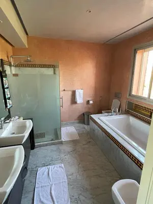 a bathroom with a tub and a sink and a bath tub at La Villa Ocre in Marrakech