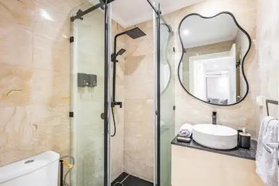 a bathroom with a shower with a sink and a mirror at Dreamy Home Climatisation and design in Oulad Akkou
