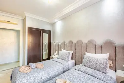 a bedroom with two beds and a large headboard at Dreamy Home Climatisation and design in Oulad Akkou