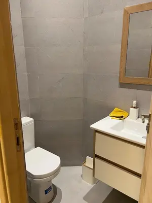 a bathroom with a toilet and a sink and a mirror at Luxury apartment - Quiet and family-friendly neighborhood in Marrakech