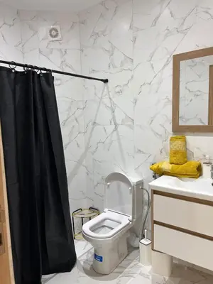a bathroom with a toilet and a black shower curtain at Luxury apartment - Quiet and family-friendly neighborhood in Marrakech