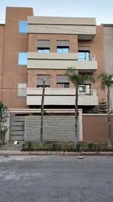 a building with palm trees in front of it at Luxury apartment - Quiet and family-friendly neighborhood in Marrakech