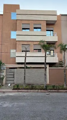 a building with palm trees in front of it at Luxury apartment - Quiet and family-friendly neighborhood in Marrakech