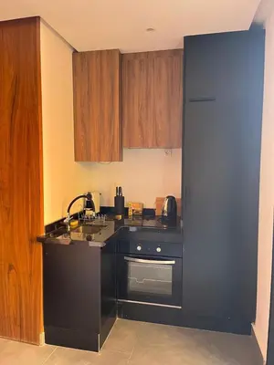 a kitchen with a black counter and wooden cabinets at Evasion à Marrakech very centrally located in Marrakech