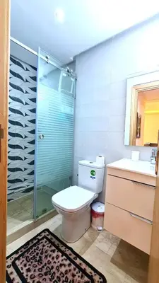 a bathroom with a toilet and a glass shower at דירת