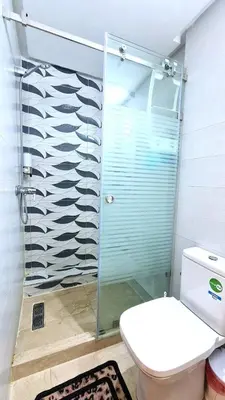 a bathroom with a glass shower with a toilet at דירת