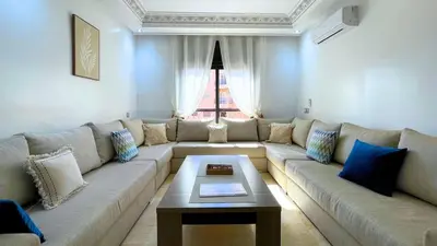 a living room with a large couch and a coffee table at Beautiful Bright Apartment Victor Hugo District in Marrakech