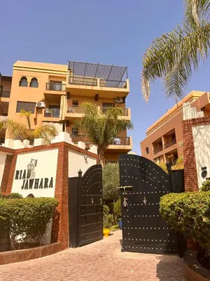 a building with a black gate in front of a building at App RIAD JAWHARA in Marrakech