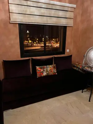 a black couch in a living room with a window at App RIAD JAWHARA in Marrakech