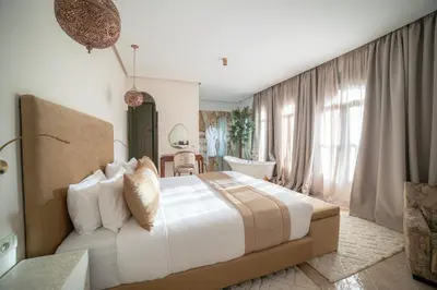 a bedroom with a large bed and a bathroom at Kasbah La Moun Luxury Riad & Spa in Marrakech