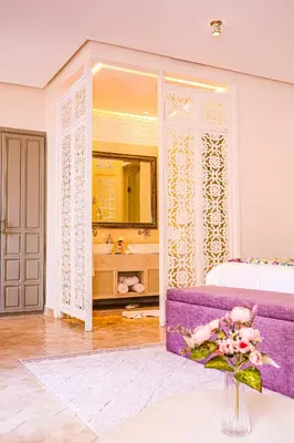 a bedroom with a purple bed and a mirror at Kasbah La Moun Luxury Riad & Spa in Marrakech