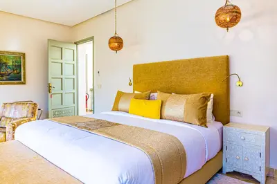 a bedroom with a large white bed with yellow pillows at Kasbah La Moun Luxury Riad & Spa in Marrakech