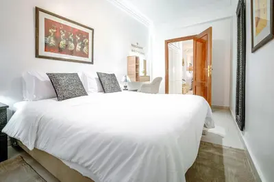 a white bedroom with a large white bed in it at Appartement de charme à Gueliz - Centre Marrakech in Marrakech