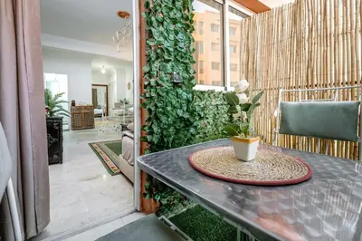 a room with a table and a green wall at Appartement de charme à Gueliz - Centre Marrakech in Marrakech