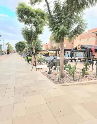 a street with palm trees in front of a building at Penthouse Prestigia Village Panoramique sur le Lac in Marrakech