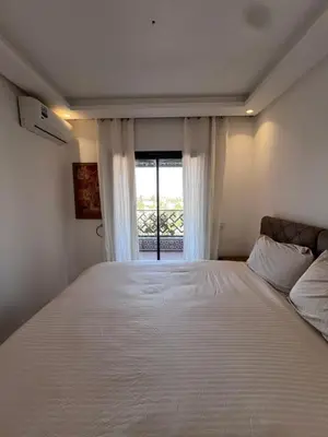 a bedroom with a large white bed with a window at Azzizi in Marrakech