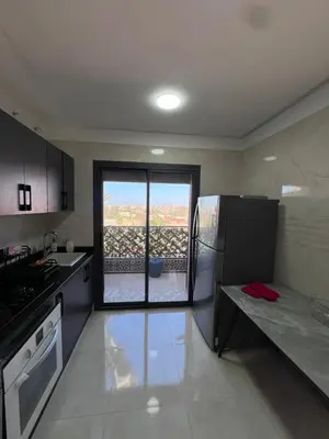 a kitchen with a refrigerator and a sliding glass door at Azzizi in Marrakech