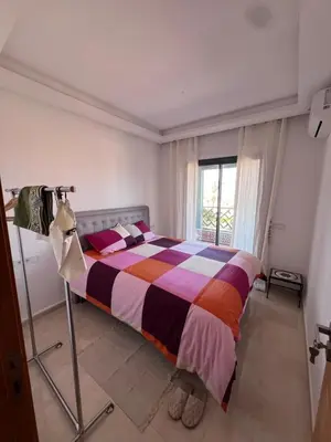 a bedroom with a bed with a colorful striped comforter at Azzizi in Marrakech